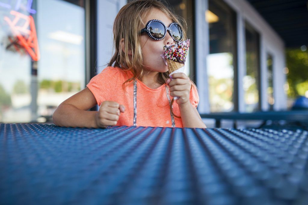 Girl In Sunglasses Eating Ice Cream At Ice Cream Parlor